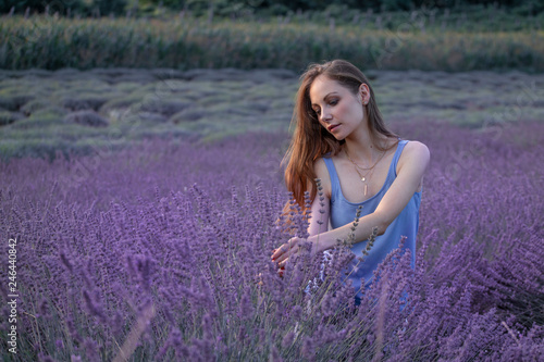 Young long hair beautiful girl standing in the middle of lavanda field