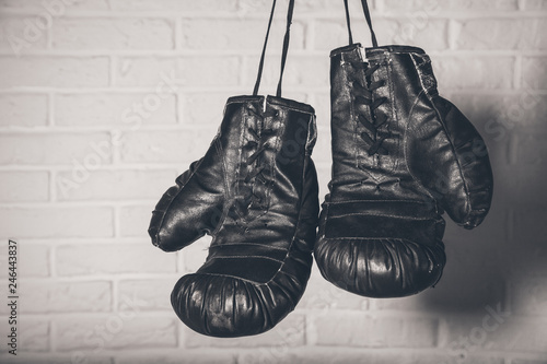 Hanging Boxing gloves on brick wall background © ARAMYAN