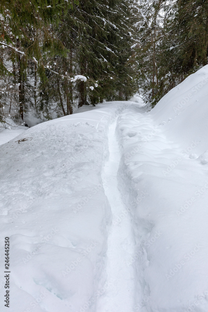 Mountain road covered in snow with footprints Mountain road covered in snow with footprints