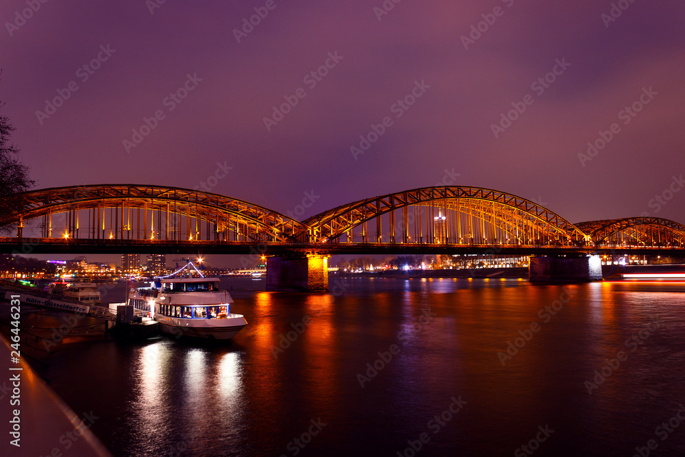 Railroad Hohenzollern bridge in Cologne, Germany and Rhine river at night