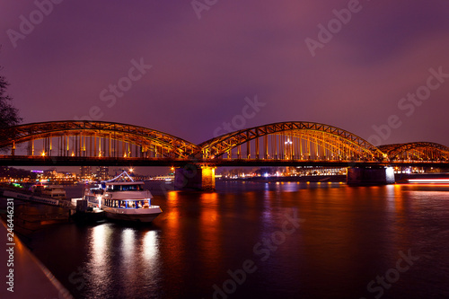 Railroad Hohenzollern bridge in Cologne, Germany and Rhine river at night