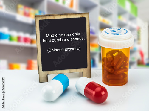 Informational Sign in a pharmacy, Medicine can only heal curable diseases. (Chinese proverb),  on a whiteboard next to bottles of medicines, conceptual image