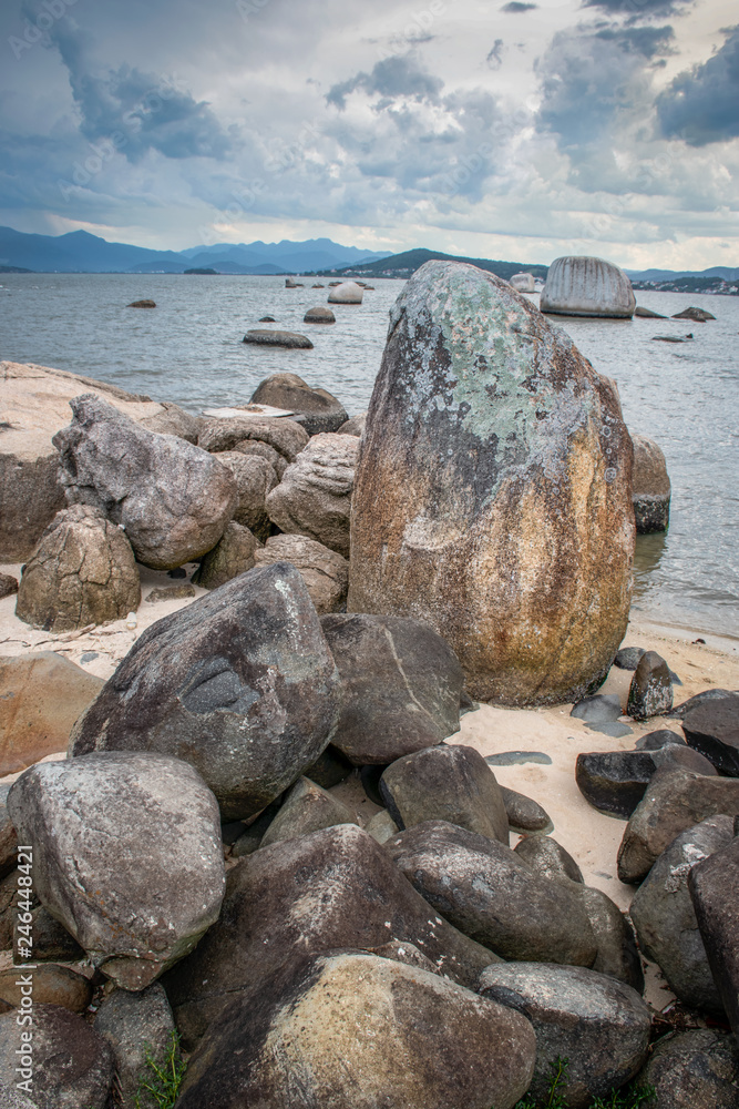 Fotografia com pedras em primeiro plano, mar e nuvens no céu azul no final da tarde. Arte para quadros fineart, impressão de quadros. Fotografia com pedras em primeiro plano, mar e nuvens no céu azul no final da tarde. Arte para quadros fineart, impressão de quadros.