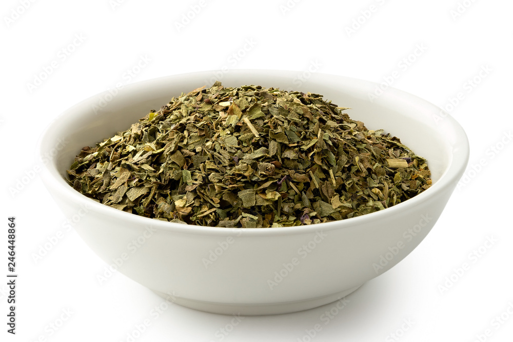 Dried chopped basil in white ceramic bowl isolated on white. Dried chopped basil in white ceramic bowl isolated on white.