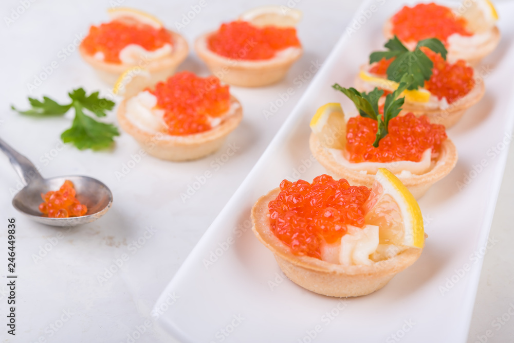 Tartlets with red caviar on white background. Selective focus. Tartlets with red caviar on white background. Selective focus.