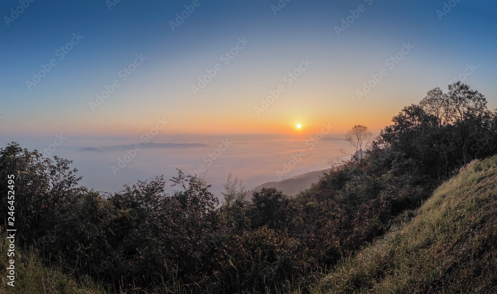 sunrise at Doi Samur Dao, mountain view misty morning of the hill around with sea of mist with colorful of yellow sun light in the sky background, Sri Nan National Park, Nan Province, Thailand. sunrise at Doi Samur Dao, mountain view misty morning of the hill around with sea of mist with colorful of yellow sun light in the sky background, Sri Nan National Park, Nan Province, Thailand.