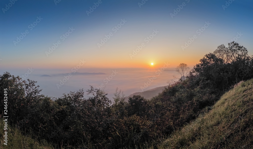 sunrise at Doi Samur Dao, mountain view misty morning of the hill around with sea of mist with colorful of yellow sun light in the sky background, Sri Nan National Park, Nan Province, Thailand.