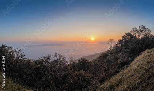 sunrise at Doi Samur Dao, mountain view misty morning of the hill around with sea of mist with colorful of yellow sun light in the sky background, Sri Nan National Park, Nan Province, Thailand.