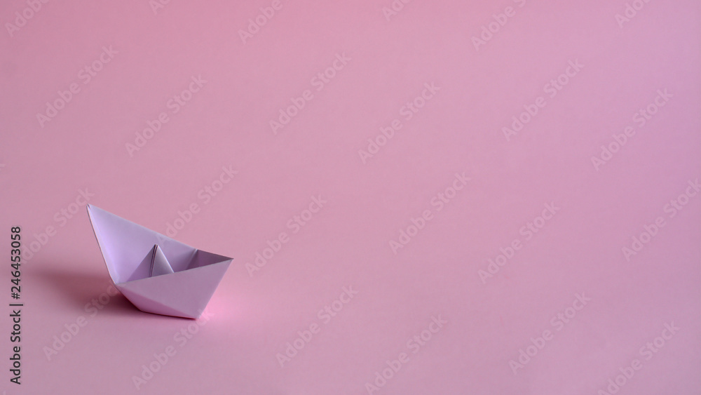 Purple paper boat on a light pink background. Feminism, gender equality. A poster for a gynecologist's office. Medicines for vaginal problems. Purple paper boat on a light pink background. Feminism, gender equality. A poster for a gynecologist's office. Medicines for vaginal problems.