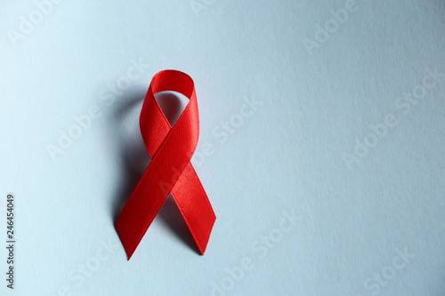 Red ribbon as symbol of aids awareness on blue  background