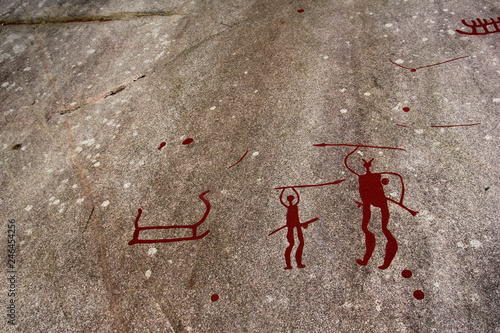 A prehistorical painting with hunting men. The drawing was made a long time ago by the cave men.  photo