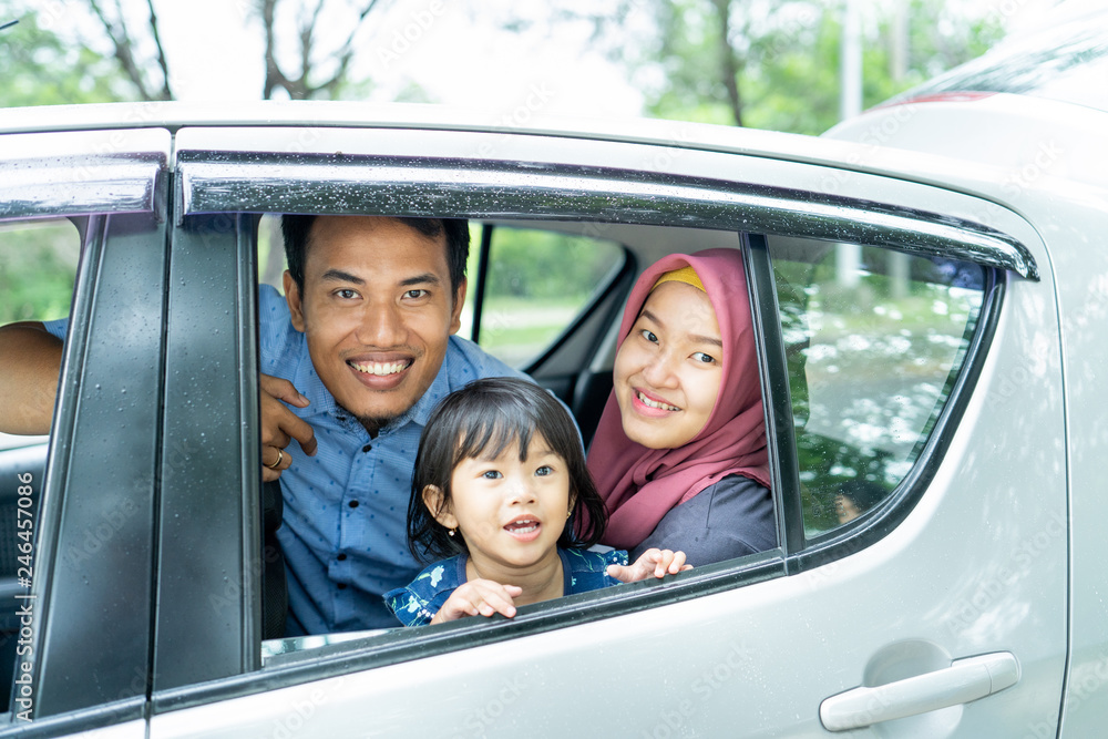 picture of family members inside a car sitting on seat back and look at camera picture of family members inside a car sitting on seat back and look at camera