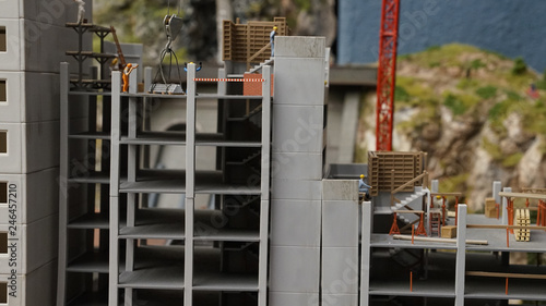  Construction site of new house with apartments with working lifting crane, new many-storied building in miniature