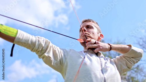 Archer pull back the string and shoots arrow