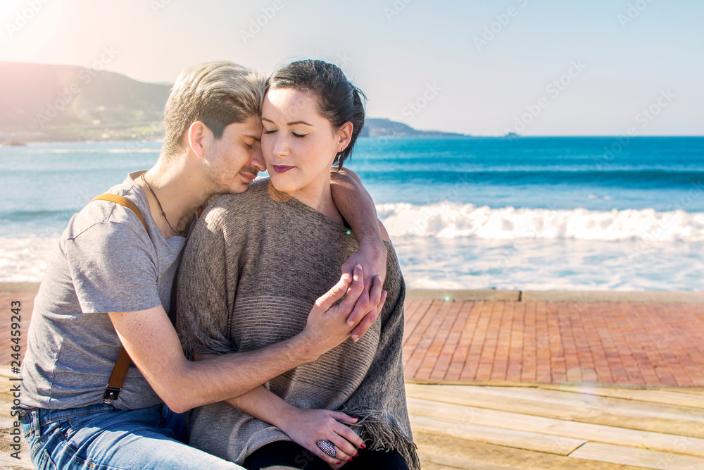 Beautiful couple who love each other, sitting by the sea.