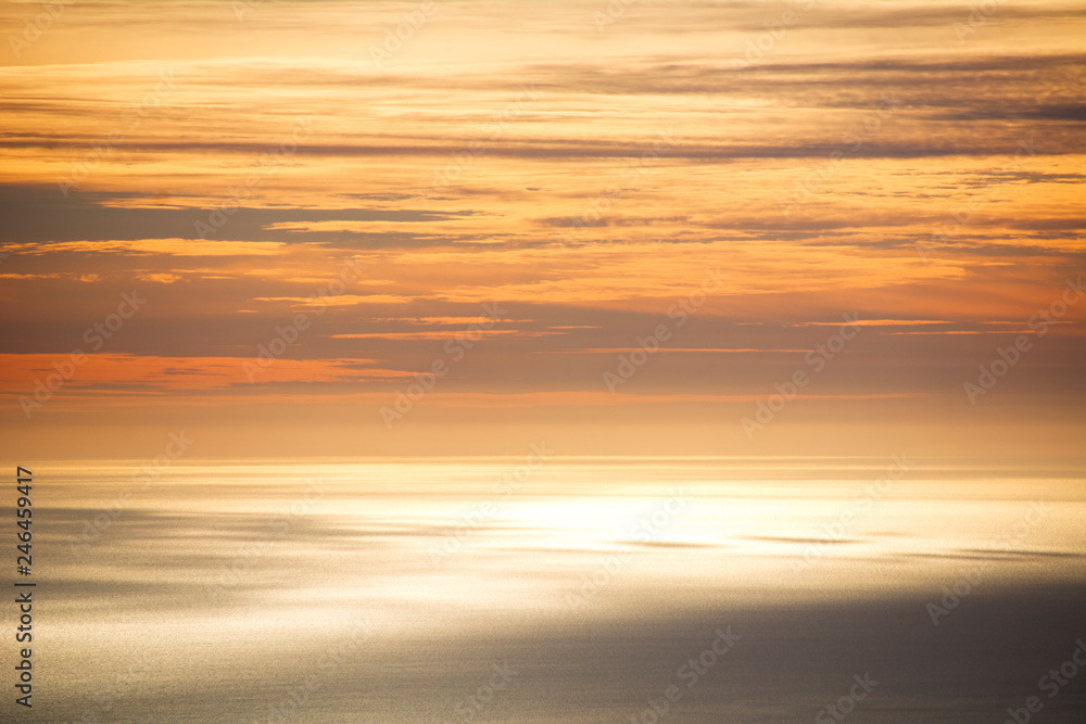 The sky and the sea are mixed in an orange color by sunset.
