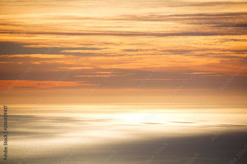 The sky and the sea are mixed in an orange color by sunset. The sky and the sea are mixed in an orange color by sunset.