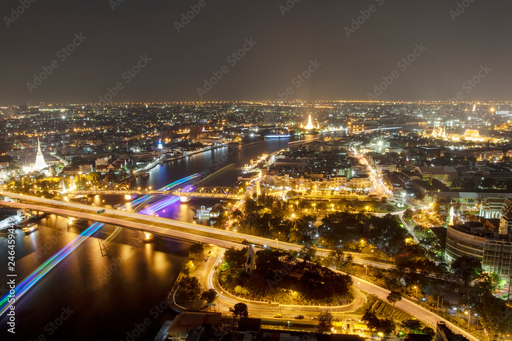 Fototapeta premium Night sky The night sky above the city with both cars and boats moving