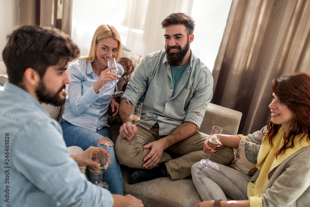 Friends with white wine smiling at home