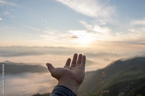Hands outstretched to receive natural light and mountain views  beautiful morning fog. hipster style.