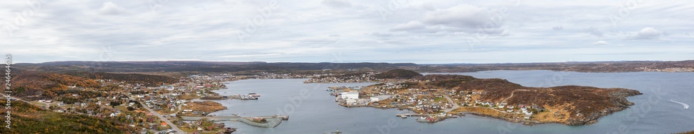 Aerial panoramic view of a town on the Rocky Atlantic Ocean Coast during a cloudy morning. Taken in St. Anthony, Newfoundland, Canada.