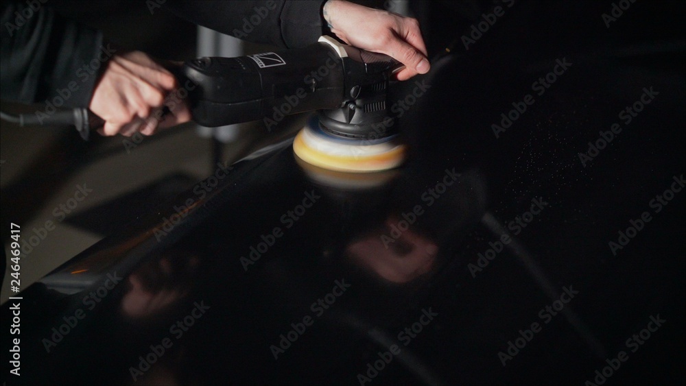 Car detailing - Hands with orbital polisher in auto repair shop. Selective focus. Car polishing and LCP correction Car detailing - Hands with orbital polisher in auto repair shop. Selective focus. Car polishing and LCP correction