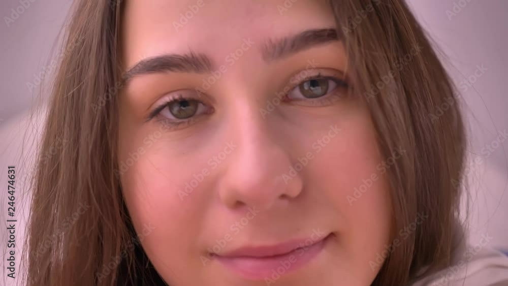 Closeup portrait of young caucasian girl with brown hair looking straight at camera and smiling Closeup portrait of young caucasian girl with brown hair looking straight at camera and smiling