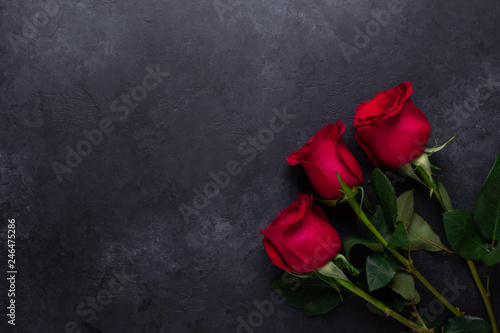 Red rose flowers bouquet on black stone background Valentine's day greeting card Copy space Flat lay