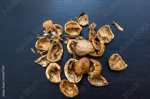 Top view of cracked walnuts shell on wooden background.