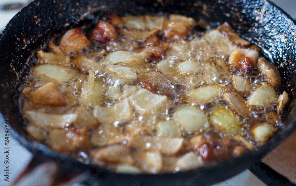 Cooking in a pan. Fat, meat, and onions are fried in the frying pan_ Cooking in a pan. Fat, meat, and onions are fried in the frying pan_