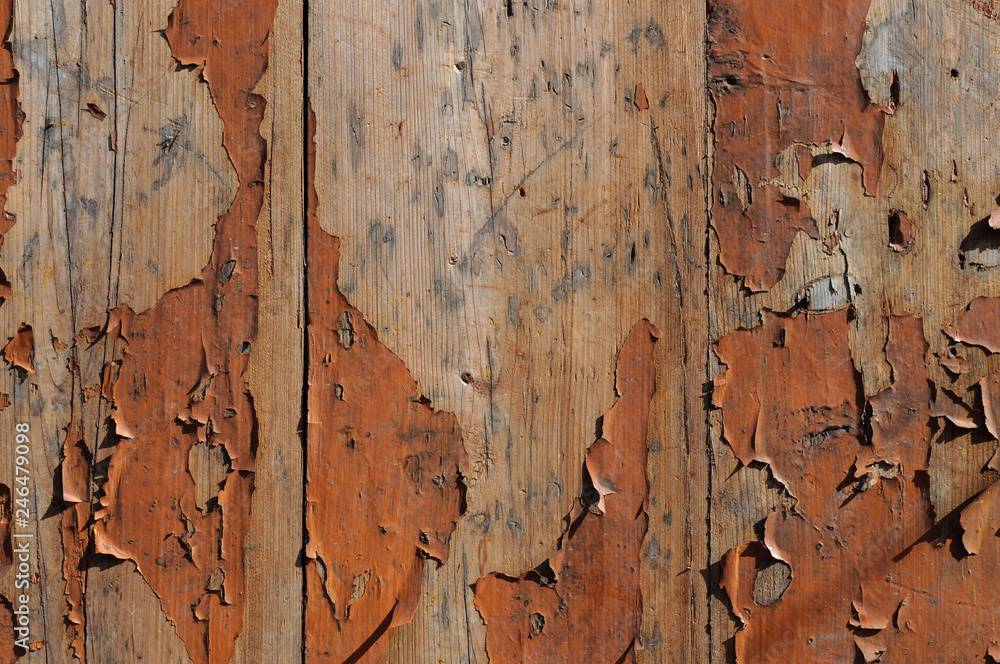 Wooden planks background with peeling red paint