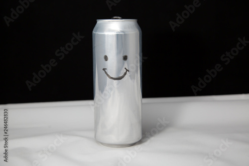 The concept of a happy look but empty in the soul of man. Smile emoticon on aluminium can, Emoji with laugh photo