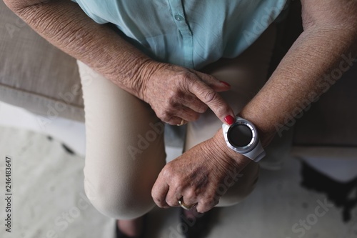 Mid section of senior woman checking time