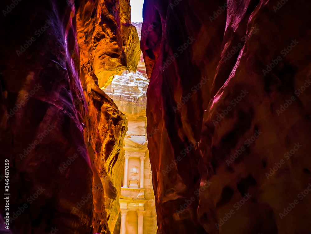 Dramatic view of a narrow canyon passage The Siq leads to The Treasury in Petra Jordan