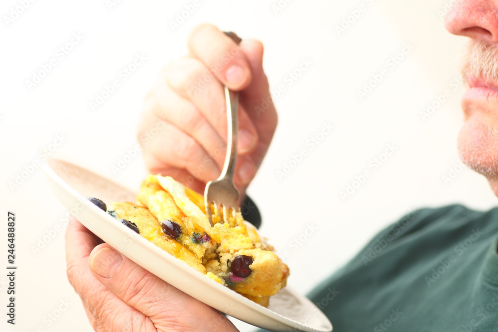 Man with plate of blueberry pancakes