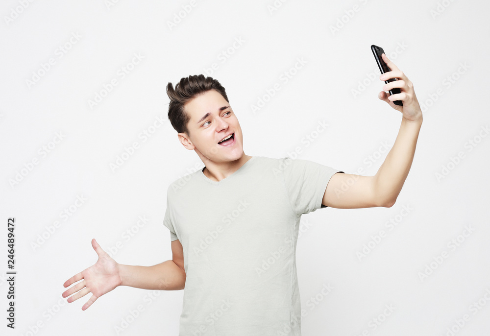 lifestyle and people concept: Photo of handsome man smiling on camera taking selfie isolated over white background lifestyle and people concept: Photo of handsome man smiling on camera taking selfie isolated over white background