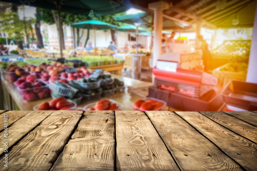 Wooden table on the street market among fresh vegetables and fruits   