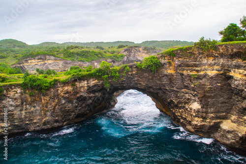 Beautiful view of unique Angels Billabong at Nusa Penida Island, Bali, Indonesia. Turquoise sea water, green grass and vacation mood. Must visit place in Bali.