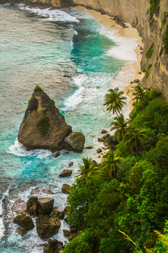 Beautiful scenic panoramic landscape view of exotic Atuh beach of Nusa Penida Island in Bali, Indonesia. Palm trees,turquoise clear water and warm white sand beach. Tourist popular dream destination.