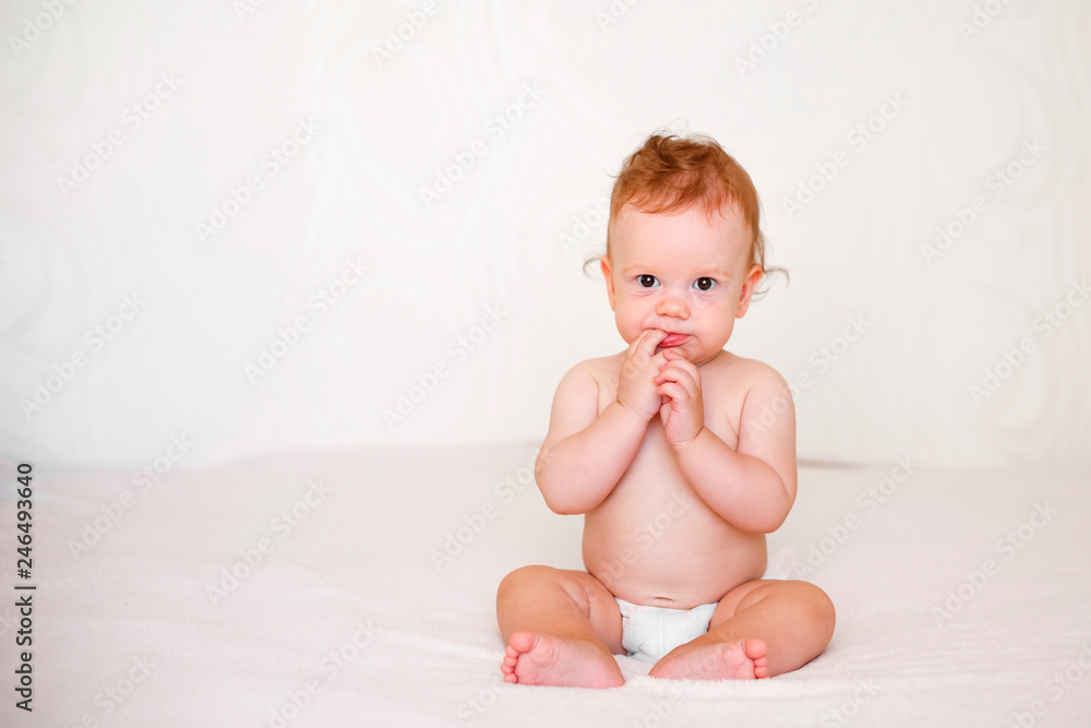 Portrait of cute redhead infant baby in diaper in light bedroom. Family, motherhood, love, health, innocence and care Portrait of cute redhead infant baby in diaper in light bedroom. Family, motherhood, love, health, innocence and care