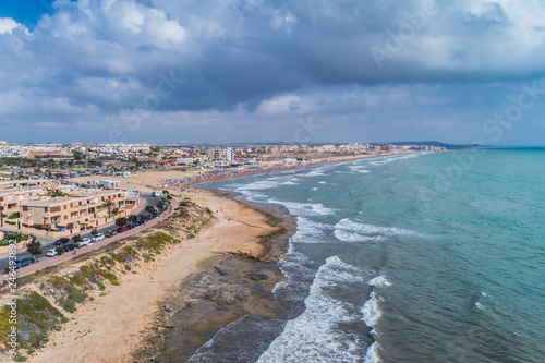 Aerial panoramic photo of La Mata Beach. Surfers ride the waves. Province of Alicante Costa Blanca. South of Spain