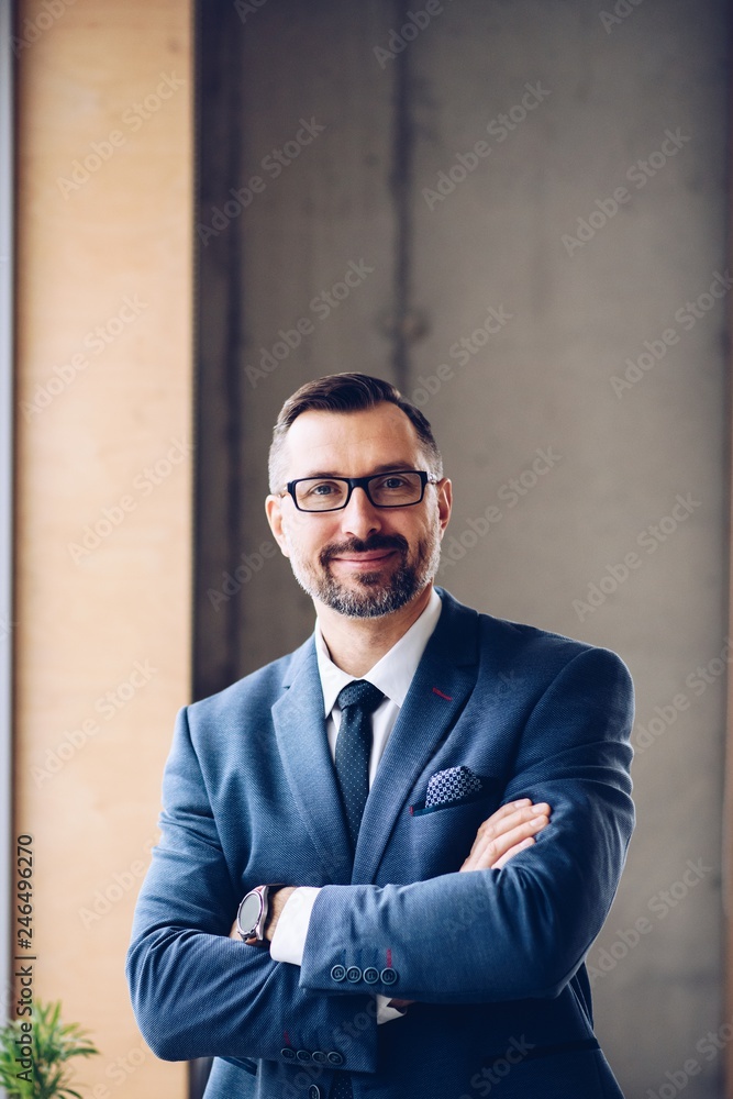 Middle aged handsome businessman in suit at office.