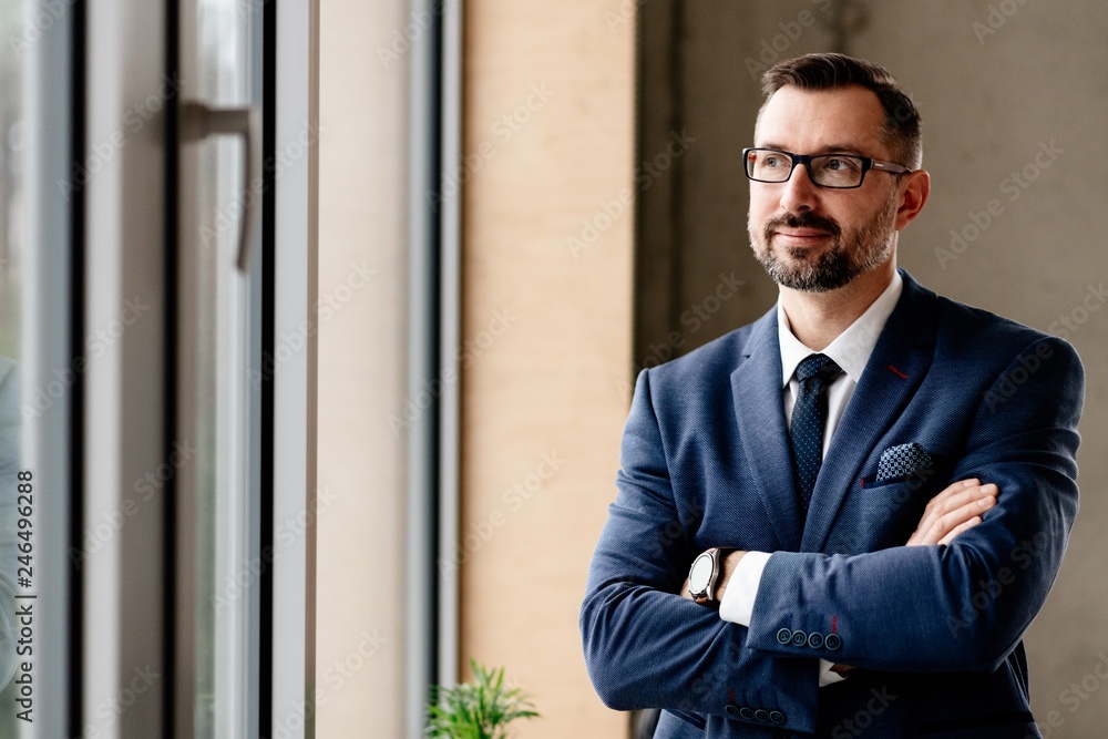 Middle aged handsome businessman in suit at office. Middle aged handsome businessman in suit at office.