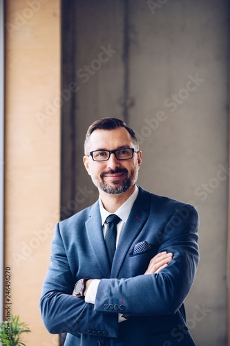 Obraz na płótnie Middle aged handsome businessman in suit at office. w salonie