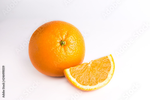 Juicy fresh orange and one orange slice. Fruits are isolated on a white background. Close photo. 