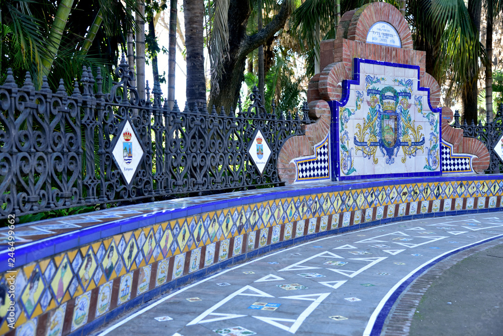 Malaga, Spain. Decorated bench - fence in the park. - obrazy, fototapety, plakaty 