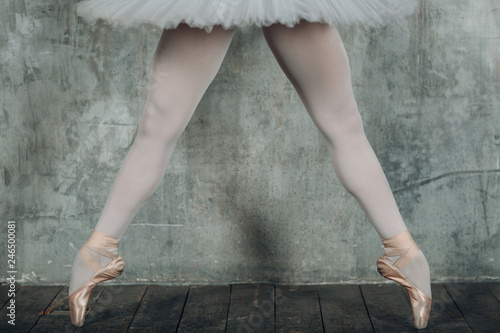 Ballerina beautiful legs. Young beautiful woman ballet dancer, dressed in professional outfit, pointe shoes and white tutu.