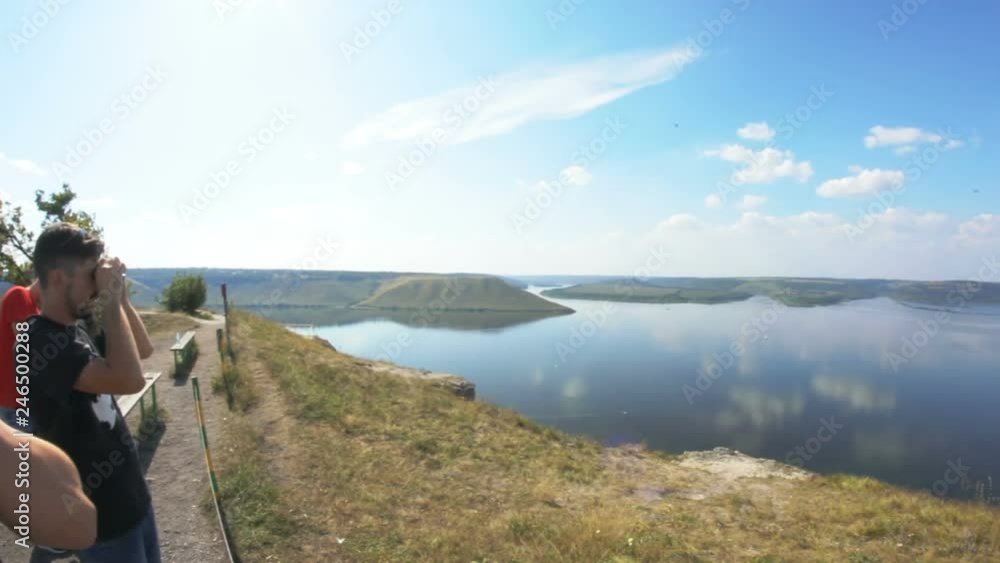 Three men standing and staring at wonderful lake and picturesque view in the countryside on hot sunny day. Three men standing and staring at wonderful lake and picturesque view in the countryside on hot sunny day.