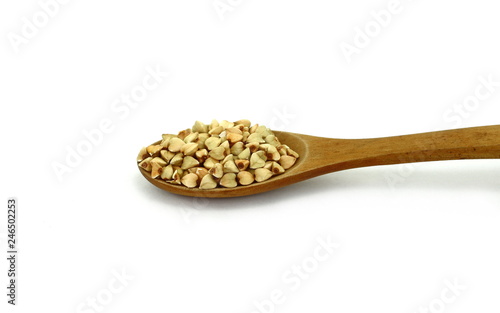 buckwheat grain in a wooden spoon isolated on white background close up. Top view. Ancooked buckwheat. photo