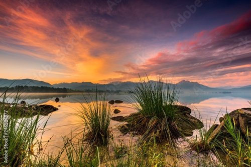 Forggensee with reflection of the cloudy sky and the Allgauer mountains in the background at sunrise, Fussen, Allgau, Bavaria, Germany, Europe
